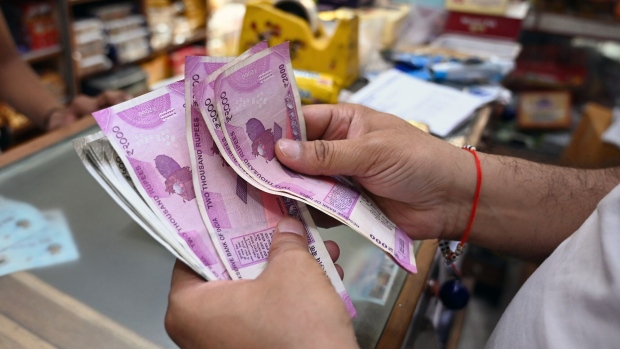 A customer counts 2,000 rupee banknotes at a grocery store in New Delhi, India, on Tuesday, May 23, 2023. India withdrawing its highest value currency notes from circulation may push some consumers to buy precious metals and real estate, giving a temporary boost to Asia's third-largest economy. Photographer: Prakash Singh/Bloomberg