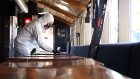 A worker disinfects tables inside a bar in Toronto, Ontario