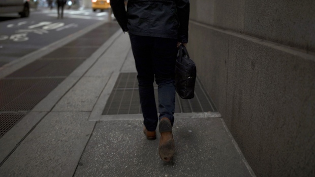 A pedestrian walks along a street near the New York Stock Exchange