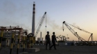 Workers walk past cranes operating at the Vadinar Refinery complex operated by Nayara Energy Ltd., formerly known as Essar Oil Ltd. and now jointly owned by Rosneft Oil Co. and Trafigura Group Pte., near Vadinar, Gujarat, India, on Wednesday, April 25, 2018. The refinery was the crown jewel in a blockbuster $13 billion acquisition that, at the time, represented the largest foreign direct investment in India's history. The deal marked Trafigura's coming of age. Photographer: Dhiraj Singh/Bloomberg