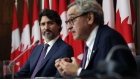 Justin Trudeau listens while Michael Sabia speaks during an Ottawa news conference on Oct. 1.