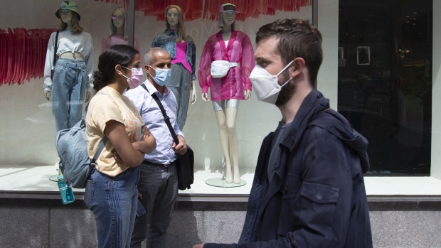 People wearing protective masks wait in line to enter at a La Maison Simons Inc. store in Montreal, Quebec, Canada, on Monday, May 25, 2020. Premier Francois Legault said in news conference in Quebec City that the province is entering "a new stage."