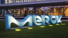 The Merck KGaA logo stands illuminated at dusk outside the pharmaceutical company's headquarters in Darmstadt.