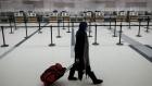A traveler wearing a protective mask walks past empty check-in counters at Pearson airport in Toronto on Feb. 1.