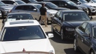 A car dealer walks past cars for sale at a used car dealership in Jersey City, New Jersey, U.S, on Wednesday, May 20, 2020. 