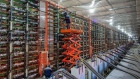 An engineer on a cherry picker adjusts mining rigs at the CryptoUniverse cryptocurrency mining farm in Nadvoitsy, Russia, on Thursday, March 18, 2021. The rise of Bitcoin and other cryptocurrencies has prompted the greatest push yet among central banks to develop their own digital currencies. Photographer: Andrey Rudakov/Bloomberg