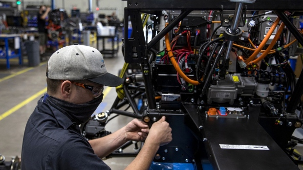 A worker attaches the front clip to the backbone on a three-wheeled electric fun utility vehicle (FUV) at the Arcimoto manufacturing facility in Eugene, Oregon, U.S., on Monday, April 19, 2021. Markit is scheduled to release manufacturing figures on April 23. Photographer: Alisha Jucevic/Bloomberg