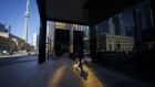 A pedestrian walks on the sidewalk in the financial district of Toronto, Ontario, Canada, on Friday, May 22, 2020. Whether the PATH, a subterranean network that provides connections between major commuter stations, over 80 properties, including the headquarters of Canada's five largest banks, and 1,200 retail spots, can return to its glory days will depend initially on how quickly Bay St. firms return workers to their offices. Photographer: Cole Burston/Bloomberg