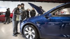 Customers look at a Tesla Inc. Model Y electric vehicle at the automaker's showroom in Shanghai, China, on Friday, Jan. 8, 2021. Tesla customers in China wanting to get the new locally made Model Y are facing a longer wait, signaling strong initial demand for the Shanghai-built SUV.