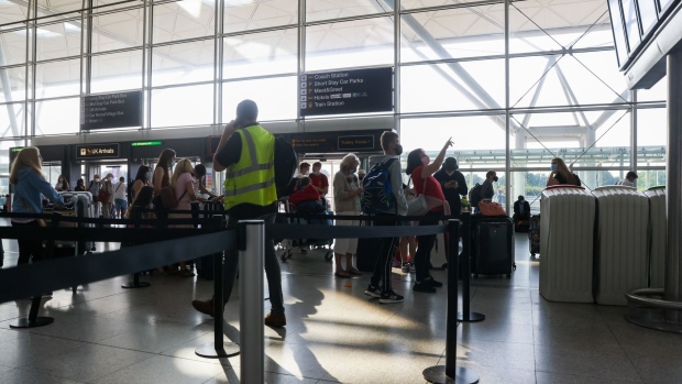 Passengers check an information screen in the check-in area at London Stansted Airport, operated by Manchester Airport Plc, in Stansted, U.K.