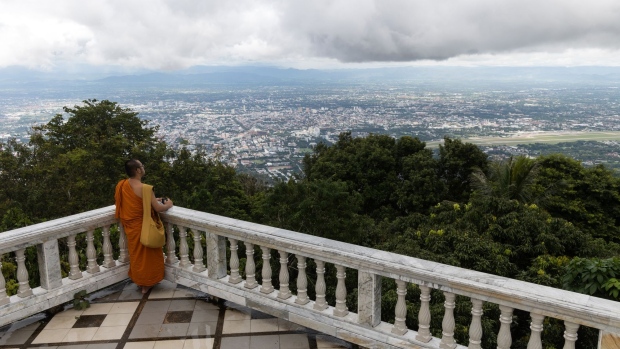A monk looks out from the deserted viewing platform at Wat Suthep in Chiang Mai, Thailand. Photographer: Luke Duggleby/Bloomberg