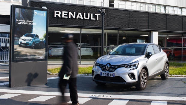 A Renault Espace Initiale SUV beside an advertisement for a Renault Twingo electric automobile at a Renault SA showroom in Paris, France, on Wednesday, April 21, 2021. Renault will eventually recover though it still has a few more tough months to get through, Chief Executive Officer Luca de Meo told French weekly newspaper Le Journal Du Dimanche in an interview. Photographer: Nathan Laine/Bloomberg