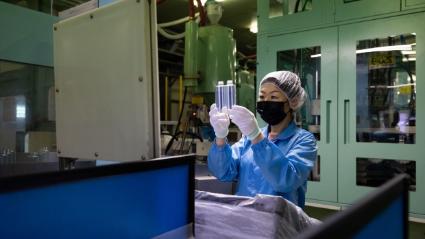 A worker wearing a protective mask inspects plastic cosmetic bottles on the production line at the Taejin Chemical co. factory in Hwaseong, South Korea, on Thursday, May 27, 2021. The Bank of Korea boosted its growth outlook for this year to 4 percent and its inflation projection to 1.8 percent. Photographer: SeongJoon Cho/Bloomberg