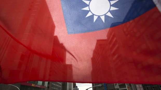 A Taiwanese flag flies in front of buildings in Taipei, Taiwan, on Monday, Nov. 9, 2015. Photographer: Tomohiro Ohsumi/Bloomberg