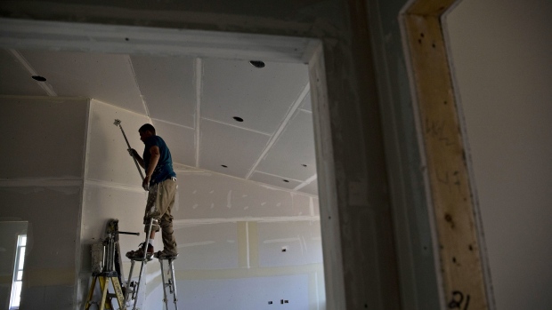 A finisher places tape on drywall seams inside a new home under construction in Plano, Illinois.