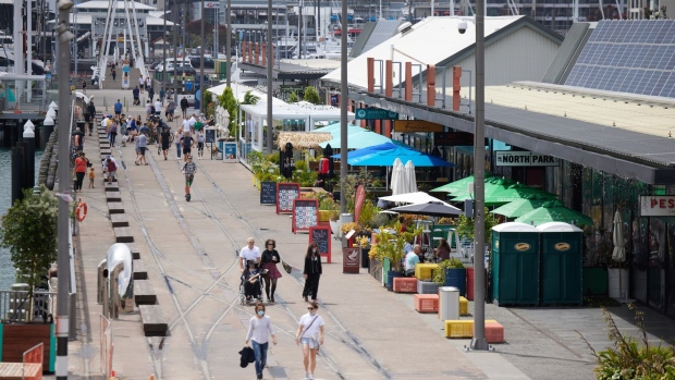 Pedestrians walk past cafes and restaurants in Auckland, New Zealand, on Sunday, Dec. 5.