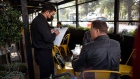 A server takes an order from a customer at a restaurant as proof of vaccination requirements are in effect in San Francisco, California, U.S., on Tuesday, Aug. 24, 2021. San Francisco has become the first major city in the United States to require proof of full vaccination against Covid-19 for a variety of high-risk indoor activities that involve eating, drinking or exercising.