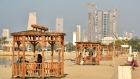 People enjoying the weather on a Kuwaiti beach under marine umbrellas - Shuwaikh Beach , in Kuwait CIty on January 8, 2022.