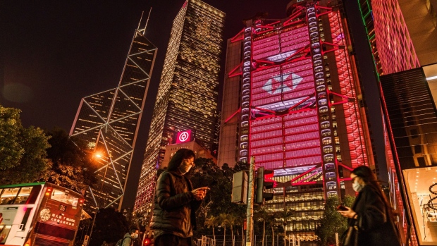 Pedestrians pass the illuminated HSBC Holdings Plc headquarters at night in Hong Kong, China, on Monday, Jan. 25, 2021. HSBC's Chief Executive Officer Noel Quinn is set to appear before the U.K. Parliament Foreign Affairs Committee to answer questions over the lenders moves to freeze accounts of activists in Hong Kong, according to an exiled lawmaker.