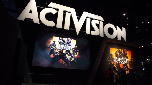 Attendees stand next to signage for Activision Blizzard Inc. Call Of Duty: Black Ops 4 video game during the E3 Electronic Entertainment Expo in Los Angeles, California, U.S., on Tuesday, June 12, 2018. For three days, leading-edge companies, groundbreaking new technologies and never-before-seen products is showcased at E3. Photographer: Troy Harvey/Bloomberg