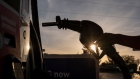 A driver holds a fuel nozzle at a gas station in Sacramento, California. Photographer: David Paul Morris/Bloomberg