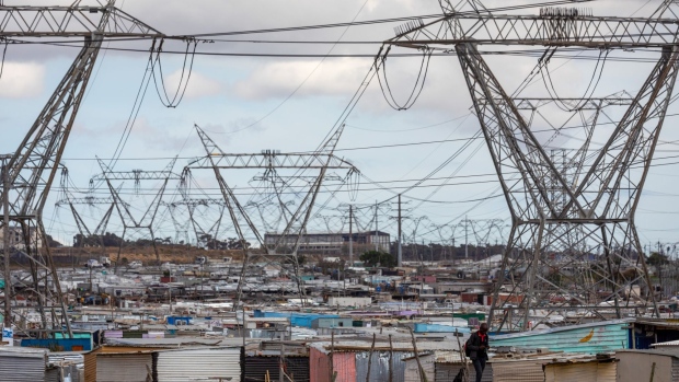 Electricity transmission pylons in the Dunoon informal settlement in Cape Town, South Africa, on Thursday, March 3, 2022. Eskom Holdings SOC Ltd., South Africa’s indebted power utility, is considering selling distribution assets as prospects of the government taking over about half of its 392 billion rand ($26 billion) obligations dim, people with knowledge of the matter said. Photographer: Dwayne Senior/Bloomberg