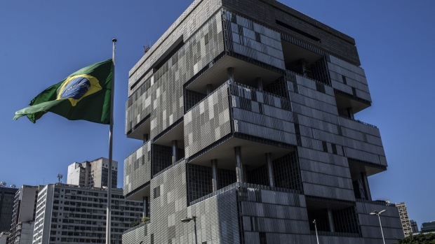 A Brazilian flag flies outside Petroleo Brasileiro SA (Petrobras) headquarters in Rio de Janeiro, Brazil, on Monday, July 29, 2018. Jose Salim Mattar, the ministry of economy's privatizer-in-chief, is on a mission to sell over 100 state-controlled companies from electricity generators to the postal service to the government's crown jewels -- the nation's largest public enterprises including Petrobras.