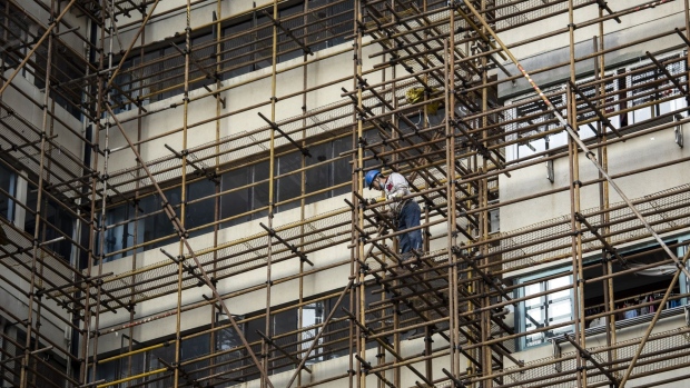 A worker stands on a scaffolding in Shanghai, China, on Friday, Feb. 27 2022. China's Politburo vowed to strengthen macroeconomic policies to stabilize the economy this year, suggesting more support could be on the cards to boost growth ahead of a key leadership meeting later this year. Photographer: Qilai Shen/Bloomberg