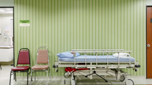 A hospital bed and chairs sits in a corridor at the Tun Hussein Onn National Eye Hospital in Petaling Jaya, Selangor, Malaysia, on Tuesday, July 10, 2018. About 14 million people spent $68 billion on medical tourism in 2016, according to consulting firm PwC. A growing number are Westerners headed to developing countries for cosmetic surgery or dental work, procedures that are less expensive and invasive than major operations and often aren’t covered by insurance. Photographer. Ian Teh/Bloomberg Photographer: Ian Teh/Bloomberg