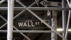 A Wall Street sign is displayed under scaffolding near the New York Stock Exchange (NYSE) in New York, U.S., on Friday, May 26, 2017. Foreign investors are coming back to the U.S. equity market in a big way after a two-year hiatus, lured by a softening dollar and diminishing odds that the Federal Reserve will hasten the pace of interest-rate increases.