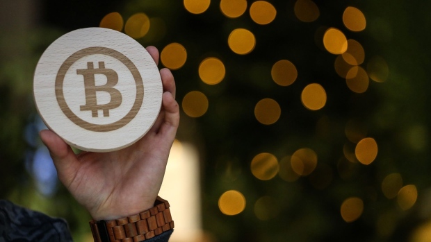 The logo of bitcoin engraved on a piece of wood in Arnhem, Netherlands, on Thursday, Nov. 10, 2022. FTX cryptocurrency exchange rattled the financial world this week when a crisis of investor confidence triggered a run, forcing the company to scramble for a buyer or bailout to avoid collapse. Photographer: Valeria Mongelli/Bloomberg