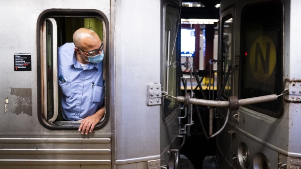 A conductor checks for commuters entering a train before departing a subway station in New York, U.S., on Friday, July 2, 2021. New York's Metropolitan Transportation Authority needs more riders to help support a record $51.5 billion capital plan to expand service throughout the New York City region and modernize its infrastructure.