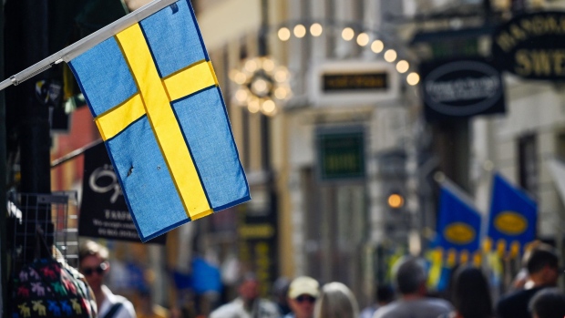 A Swedish national flag hanging from a shop in Gamla Stan in Stockholm, Sweden, on Thursday, Aug. 18, 2022. Sweden’s government forecast the economic expansion to stall next year as high inflation and rising rates weigh on household consumption. Photographer: Mikael Sjoberg/Bloomberg