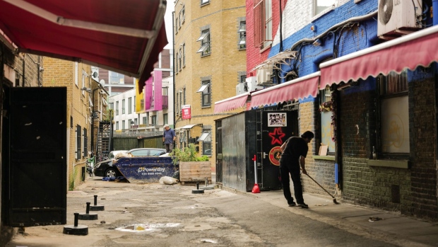 A worker cleans a street in Dalston, London, UK, on Tuesday, Aug. 16, 2022. The Office for National Statistics are due to release the latest UK CPI Inflation data on Wednesday.