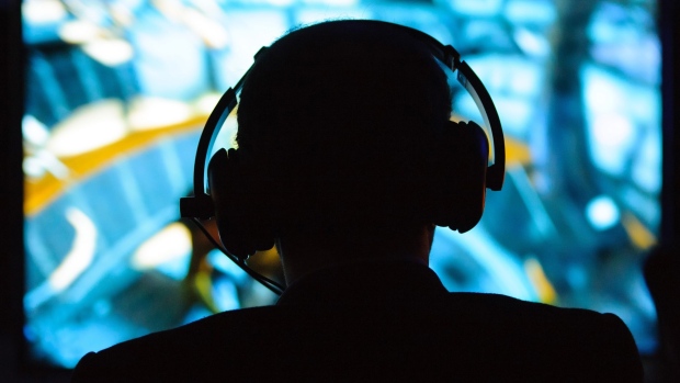 A man wearing headphones plays on a games console Photographer: Dominic Lipinski/PA Images/Getty Images