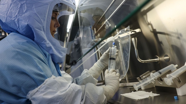 An employee uses a syringe to transfer raw materials for messenger RNA (mRNA), the first step of Covid-19 vaccine production, at the BioNTech SE laboratory in Marburg, Germany, on Saturday, March 27, 2021. BioNTech and Pfizer Inc. raised this year’s production target for their Covid-19 vaccine to as many as 2.5 billion doses, with the German biotech’s chief executive predicting a version of the shot that can be stored in refrigerators will be ready within months.