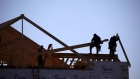 Contractors build the framing of a roof on a house under construction at the Norton Commons subdivision in Louisville, Kentucky, U.S., on Tuesday, Feb. 8, 2022. The U.S. Census Bureau is scheduled to release housing starts figures on Feb. 17.