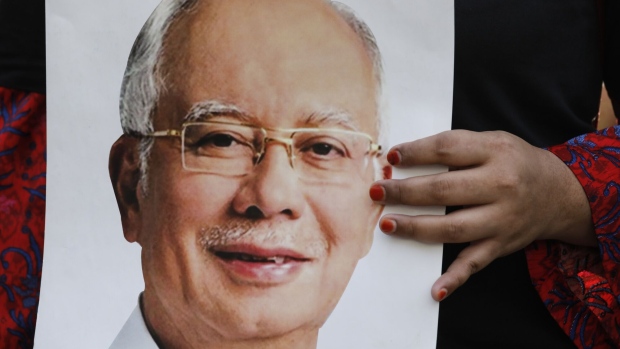 A supporter of former Prime Minister Najib Razak holds a placard outside Malaysia's Court of Appeal and Federal Court ahead of his hearing in Putrajaya, Malaysia, on Thursday, Jan. 19, 2023. Najib was back in court Thursday to request that his 1MDB-linked case be reviewed, in his latest attempt to overturn his 12-year-prison sentence. Photographer: Samsul Said/Bloomberg