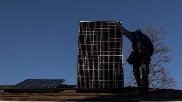A contractor carries a SunRun solar panel on the roof of a home in San Jose, California, U.S., on Monday, Feb. 7, 2022. California regulators are delaying a vote on a controversial proposal to slash incentives for home solar systems as they consider revamping the measure. Photographer: David Paul Morris/Bloomberg