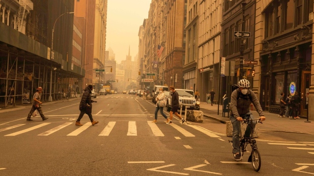 Pedestrians wear face masks as smoke from Canada wildfires blankets New York on June 7.