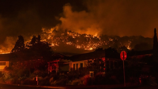 Fire burns over a ridge behind houses near the Skyhawk Park neighborhood of East Santa Rosa during the Shady Fire in Sonoma County, California, U.S., on Sunday, Sept. 27, 2020. Firefighters were battling multiple rapid growing wildfires sparked during a red flag warning in Napa and Sonoma Counties Sunday that burned structures and prompted evacuations.
