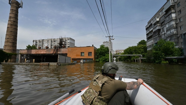 A Ukrainian serviceman sails on boat during a food delivery to the residents of a flooded area in Kherson on June 8. Photographer: Genya Savilov/AFP/Getty Images