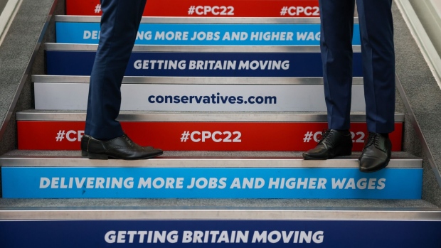 Slogans on a set of stairs during the Conservative Party's annual autumn conference in Birmingham, UK, on Monday, Oct. 3, 2022. Liz Truss is standing by her Chancellor of the Exchequer Kwasi Kwarteng after the threat of a rebellion in the ruling party forced them into a humiliating reversal on a plan to cut taxes for the top earners in the UK.