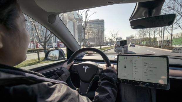 A sales assistant drives a Tesla Inc. Model Y electric vehicle in Shanghai, China, on Friday, Jan. 8, 2021. Tesla customers in China wanting to get the new locally made Model Y are facing a longer wait, signaling strong initial demand for the Shanghai-built SUV.