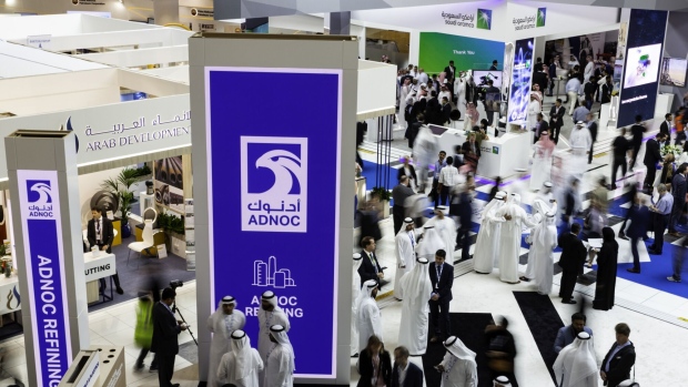 Delegates walk through the Abu Dhabi National Oil Co. (ADNOC) and Saudi Aramco displays during the Abu Dhabi International Petroleum Exhibition and Conference (ADIPEC) in Abu Dhabi, United Arab Emirates, on Tuesday, Nov. 13, 2018. Photographer: Christopher Pike/Bloomberg