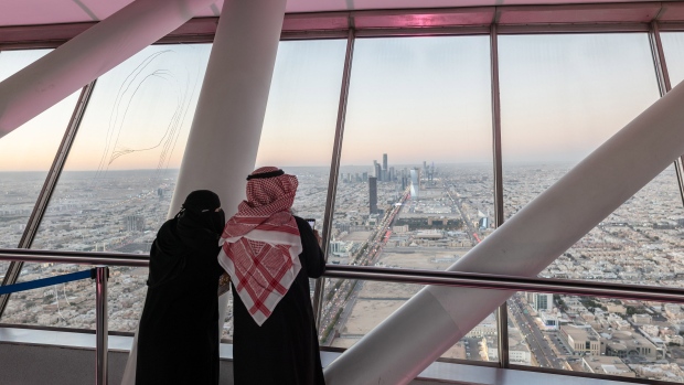 Visitors looks out towards the city skyline from the skybridge of the Kingdom Center, in Riyadh, Saudi Arabia, on Thursday, Jan. 19, 2023. Mostly shut off to foreign visitors for years, Crown Prince and de facto ruler Mohammed bin Salman has unveiled an ambitious push to use tourism as a way to help diversify the oil-dependent economy. Photographer: Jeremy Suyker/Bloomberg