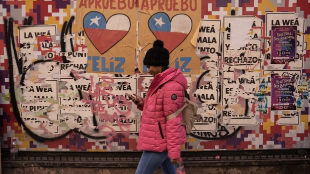 A pedestrian in front of a wall covered with posters of approval and rejection of the new Constitution in Santiago, Chile, on Thursday, July 27, 2023.