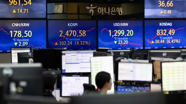 Foreign currency dealers work in a dealing room of Hana Bank in Seoul on Nov. 6. Photographer: SeongJoon Cho/Bloomberg