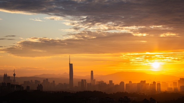 Sun rises beyond the Kuala Lumpur city skyline, seen from Petaling Jaya, Selangor, Malaysia, on Thursday, Sept. 14, 2023. Malaysia kept its benchmark interest rate unchanged yet again on Thursday, as the Southeast Asian country looks to sustain economic growth following months of slowing inflation and exports.