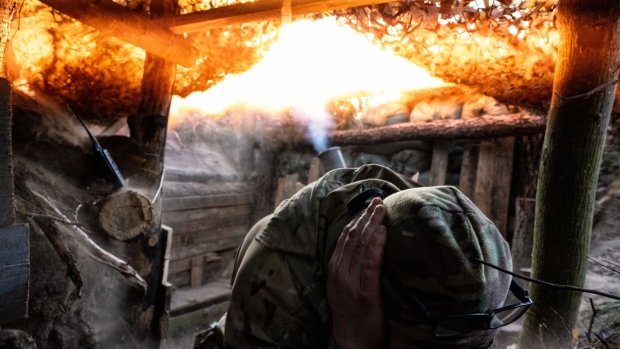 A Ukrainian soldier fires a mortar at Russian positions.